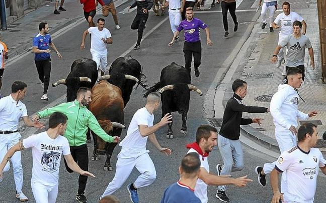 Mozos corriendo delante de las reses en la Avenida Severino Fernández, entrando a la curva de la Farola .