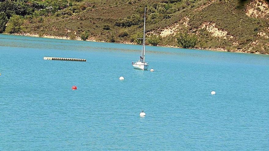 Un velero en el embalse, al fondo las orillas que serán objeto del proyecto Alloz Sostenible.