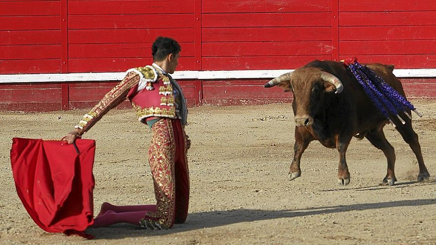 El sevillano Mariscal Cruz, sustituto de Javier Zulueta y que cortó cuatro orejas y un rabo, inicia la faena al tercero, ‘Artabano’, de rodillas y con un pase cambiado por la espalda.