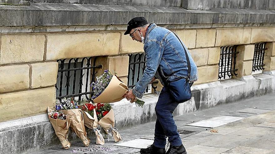 Un hombre deposita un ramo de flores en el lugar donde fue apuñalado mortalmente el joven Lukas Agirre, en Donostia. | FOTO: JAVI COLMENERO