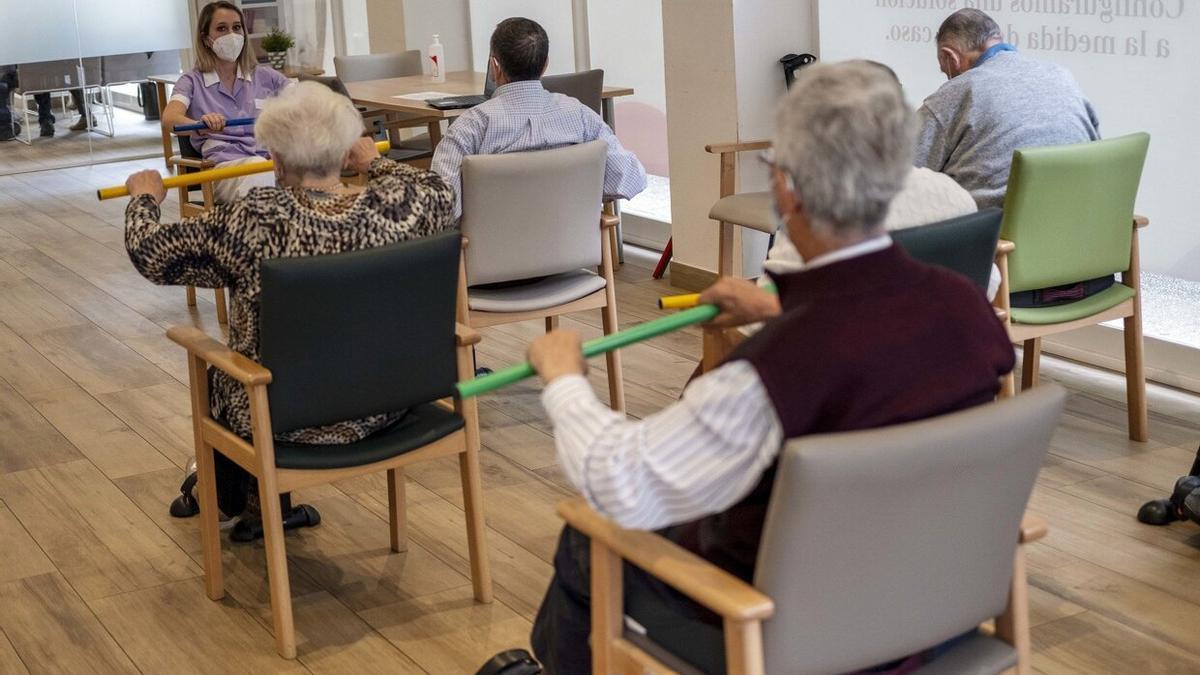 Personas mayores hacen ejercicio en un centro de día.