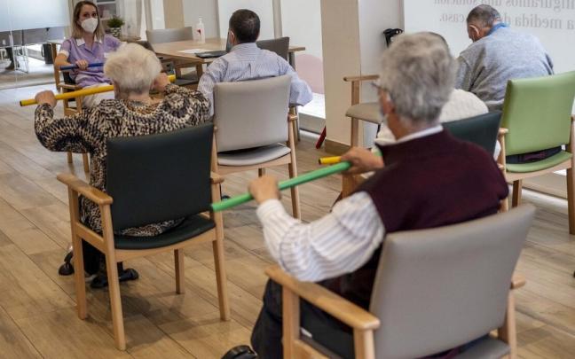 Personas mayores hacen ejercicio en un centro de día.