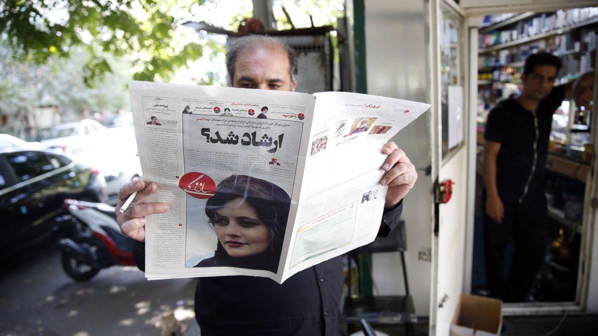 Un hombre lee un periódico con la noticia de la muerte de Mahsa Amini en portada.