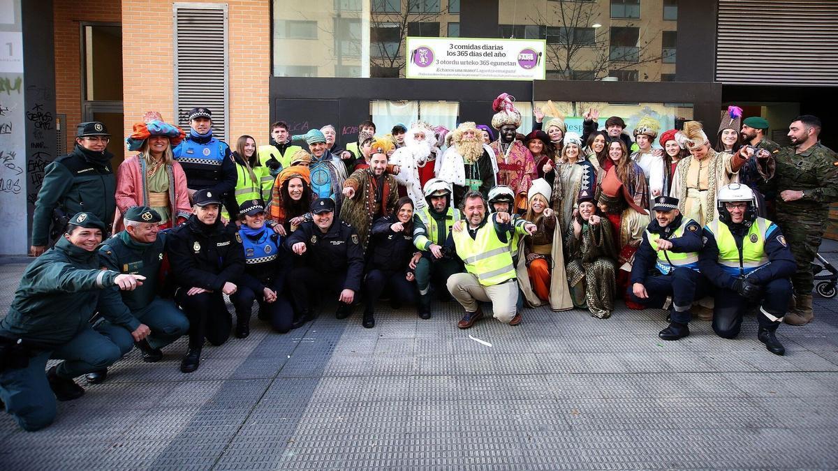 Voluntarios que han participado en la cabalgata solidaria posan frente al Comedor París 365, en la Rochapea.