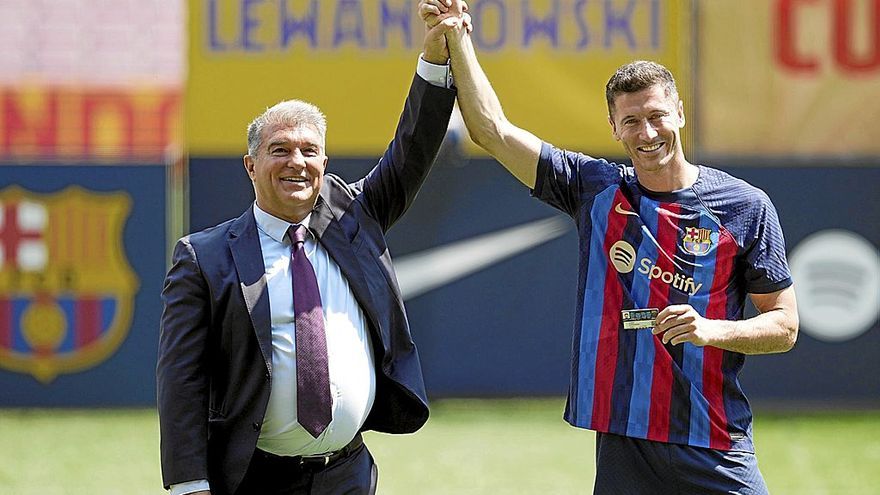 Un eufórico Joan Laporta levanta el brazo de Robert Lewandowski durante la presentación del delantero polaco como nuevo futbolista del Barcelona. | FOTO: EFE