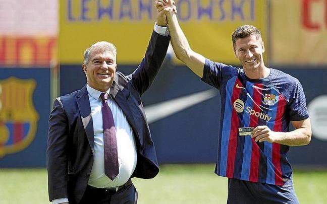 Un eufórico Joan Laporta levanta el brazo de Robert Lewandowski durante la presentación del delantero polaco como nuevo futbolista del Barcelona. | FOTO: EFE