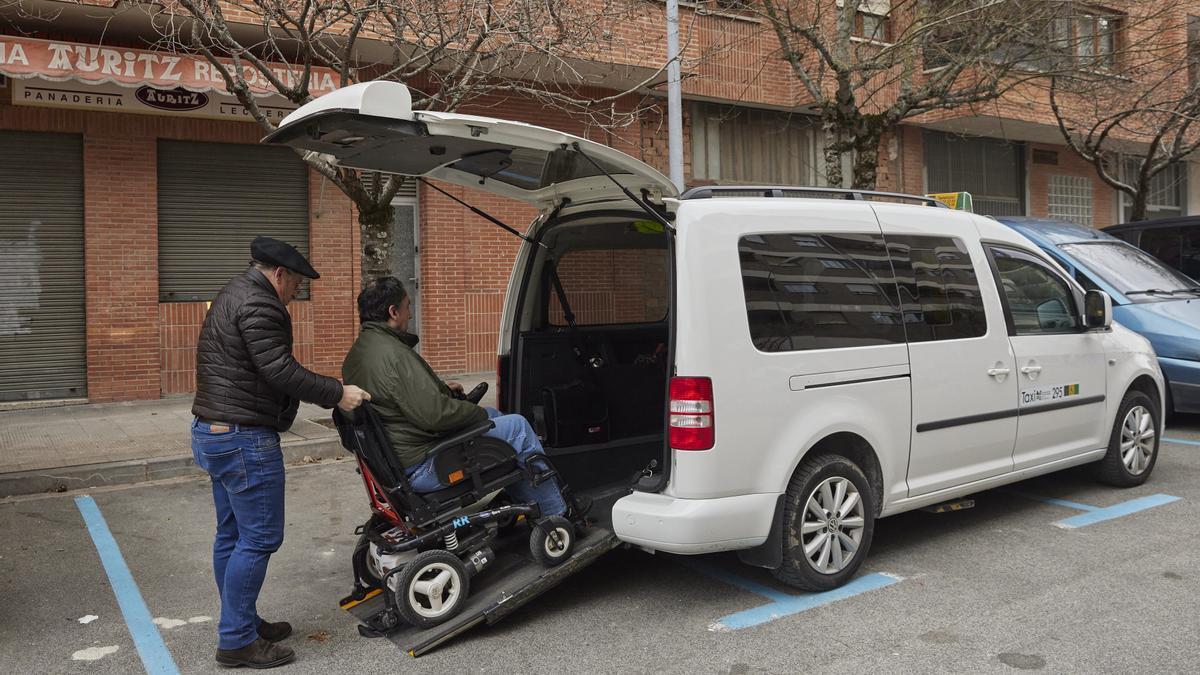 Una persona con discapacidad sube a un taxi de Pamplona.