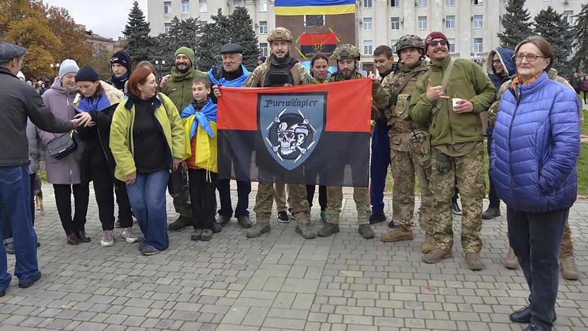 Civiles posan con soldados ucranianos frente al palacio administrativo de Jersón.