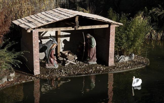 Un cisne pasa junto a un belén instalado en los fosos de La Taconera. Un cisne pasa junto a un belén instalado en los fosos de La Taconera.