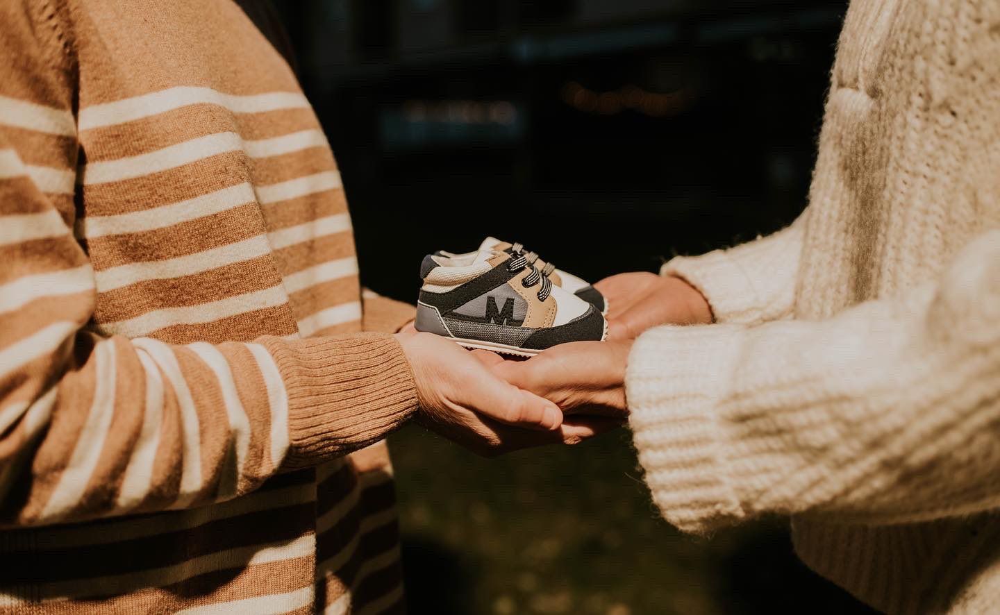 La pareja sostiene una pequeña zapatilla.