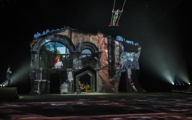 Crystal se balancea sobre el trapecio mientras su reflejo realiza un número de patinaje en solitario y la banda toca en directo.