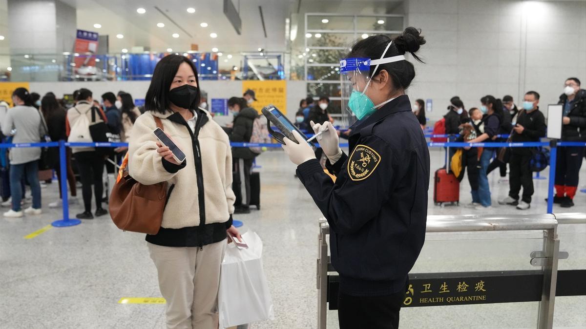 Una empleada de aduanas comprueba la información de una viajera en el aeropuerto de Shanghái
