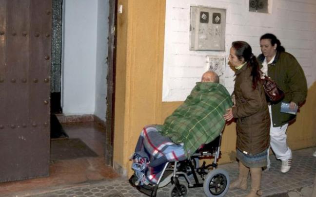 Una persona dependiente, atendida por dos mujeres en una residencia de ancianos.