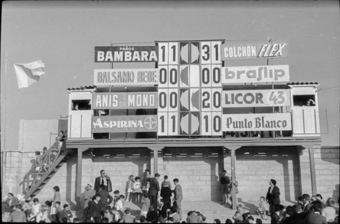 Aspecto del Marcador Simultáneo situado en uno de los Fondos (hoy Polideportivo) de Mendizorroza, junto a la valla en la que se colocaban –por orden de clasificación– todas las banderas de los rivales del Deportivo Alavés.