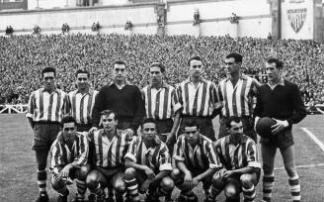 12 de setiembre de 1954. Athletic-Alavés (4-0). De pie (izda. a dcha.): Sanz, 'Primi', Berasaluce, Bolado, Gorospe, Erezuma y Carlos Larrañaga (portero suplente). Agachados (izda. a dcha.): Etxeandia, Wilson, Roth, Etxaniz e Ibarra. 12 de setiembre de 1954. Athletic-Alavés (4-0). De pie (izda. a dcha.): Sanz, 'Primi', Berasaluce, Bolado, Gorospe, Erezuma y Carlos Larrañaga (portero suplente). Agachados (izda. a dcha.): Etxeandia, Wilson, Roth, Etxaniz e Ibarra.