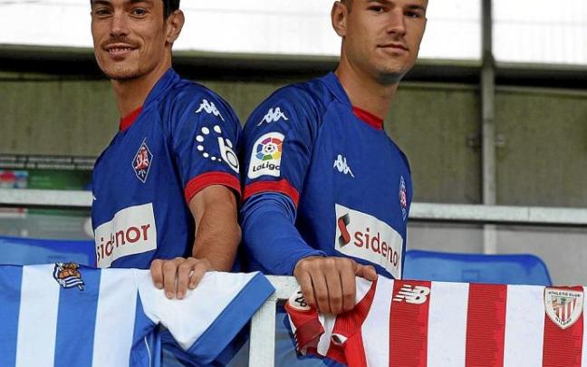 Josu Ozkoidi y Gorka Zurutuza posan con las camisetas de la Real y del Athletic.