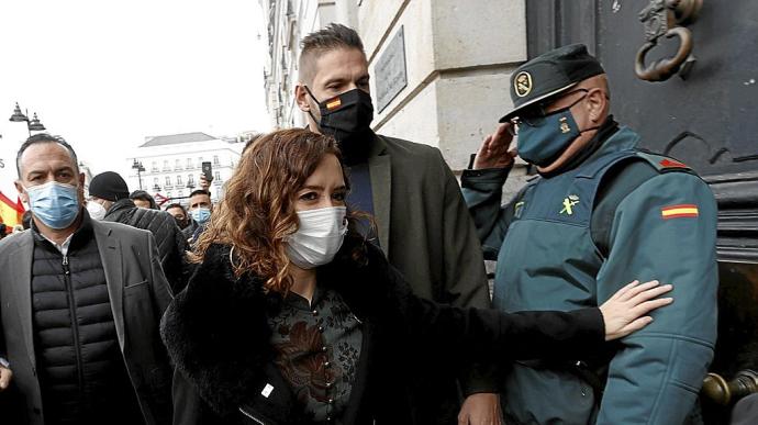 Un agente de la Guardia Civil saluda a la presidenta madrileña al inicio de la marcha de ayer contra la reforma de la ‘ley mordaza’. Foto: Efe