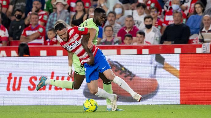 Iñaki Williams pugna con Quini por un balón en el partido disputado ayer entre el Granada y el Athletic en el Nuevo Los Cármenes.