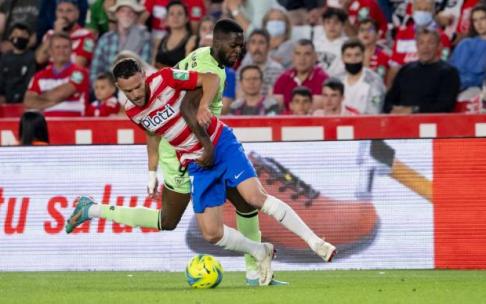 Iñaki Williams pugna con Quini por un balón en el partido disputado ayer entre el Granada y el Athletic en el Nuevo Los Cármenes.