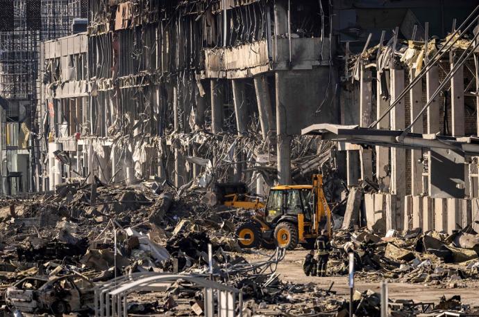 Bomberos ucranianos trabajan en los escombros de un centro comercial en Retroville.