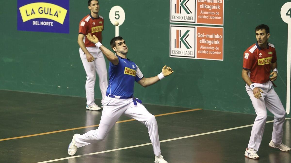 Ezkurdia se dispone a golpear la pelota en presencia de Urrutikoetxea y Albisu.