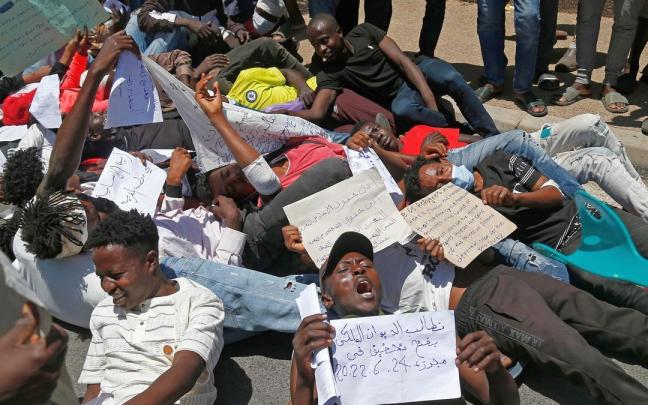 Un grupo de migrantes recrean en Melilla la imagen de los fallecidos amontonados en Nados.