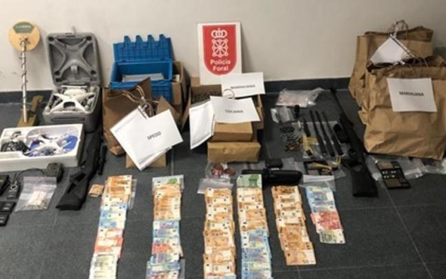 Imagen del dinero, drogas y armas intervenidas.