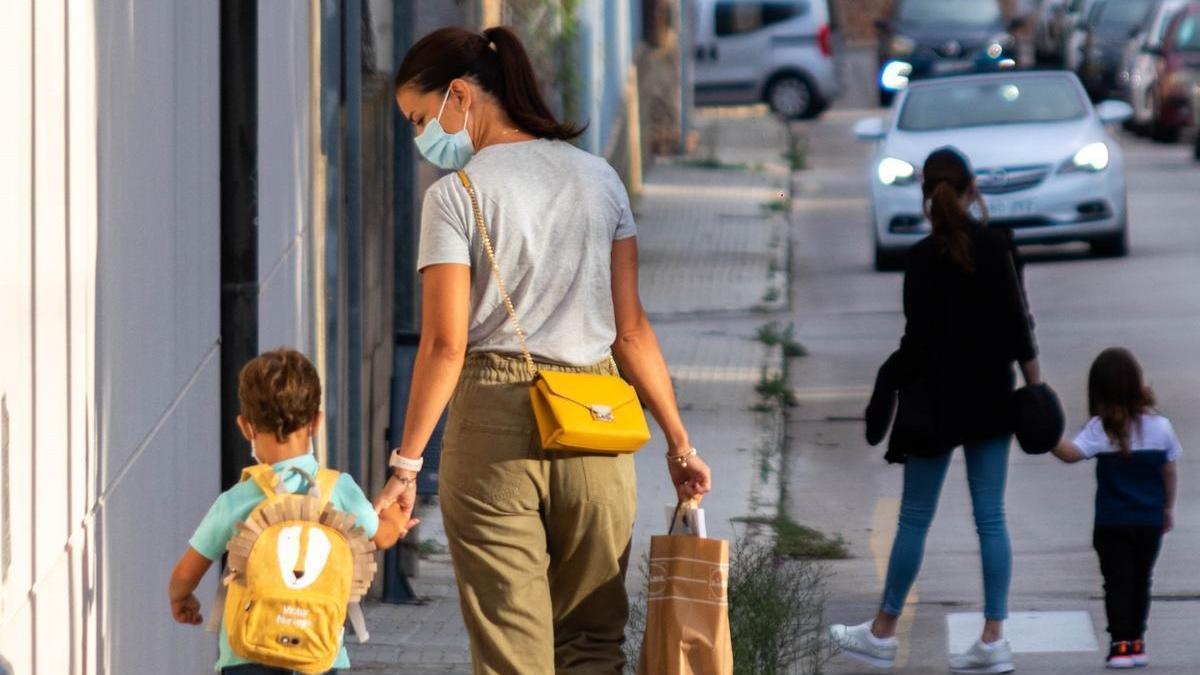 Dos mujeres pasean con sus hijos.