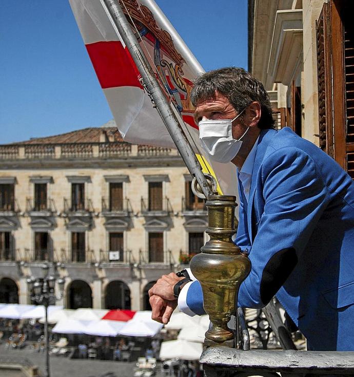 El alcalde, Gorka Urtaran, observa la Plaza Nueva desde el balcón de su despacho en el Ayuntamiento, junto al mástil donde ondea la bandera de Vitoria