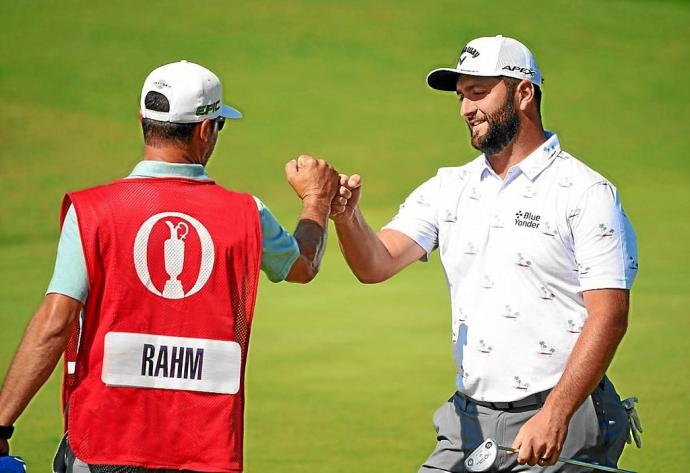 Jon Rahm celebra con su caddie Adam Hayes el birdie en el hoyo 6 ayer en The Open. Foto: Afp