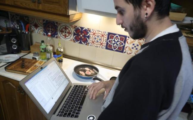 Una persona teletrabaja en la cocina de su domicilio.