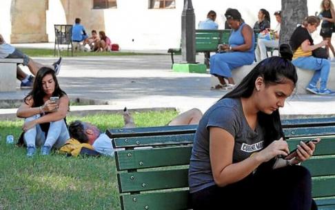 Varias personas se conectan a Internet con sus móviles a través de una conexión wifi. Foto: Efe