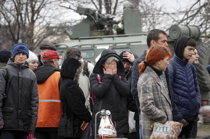 Fotografía tomada durante una visita organizada por el ejército ruso que muestra a vecinos de Mariúpol haciendo fila para conseguir suministros básicos.