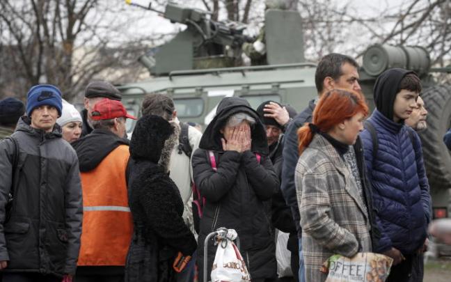 Fotografía tomada durante una visita organizada por el ejército ruso que muestra a vecinos de Mariúpol haciendo fila para conseguir suministros básicos.