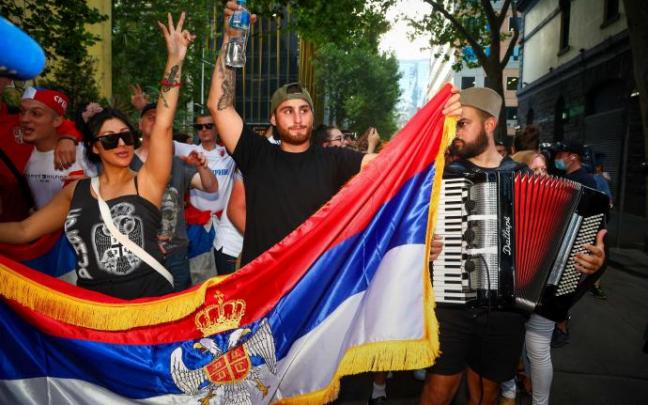 Un grupo de personas celebran el fallo judicial sobre la liberación de Djokovic en Melbourne. Un grupo de personas celebran el fallo judicial sobre la liberación de Djokovic en Melbourne.