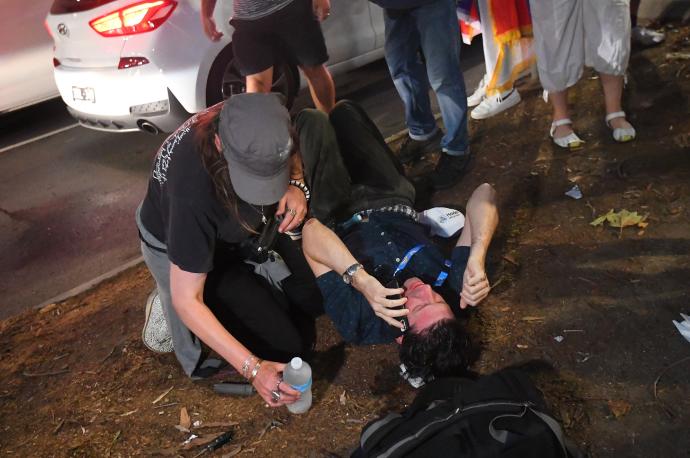 Un hombre tumbado en el suelo durante los enfrentamientos entre la Policía y seguidores de Djokovic.