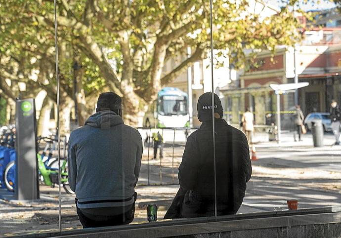 Dos hombres pasan el rato en un banco del paseo de Francia.