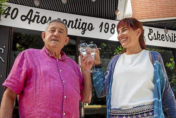 El fundador de Dolomiti, Paco Galdós (i), brinda junto a su hija, Patricia, delante de la pizzería engalanada con motivo de los 40 años que hoy festeja.