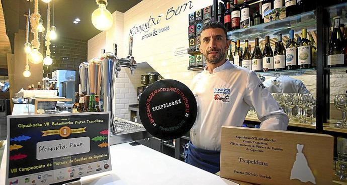 George Brezeanu posa orgulloso con su txapela dentro de la barra del bar Ramuntxo Berri de Gros.