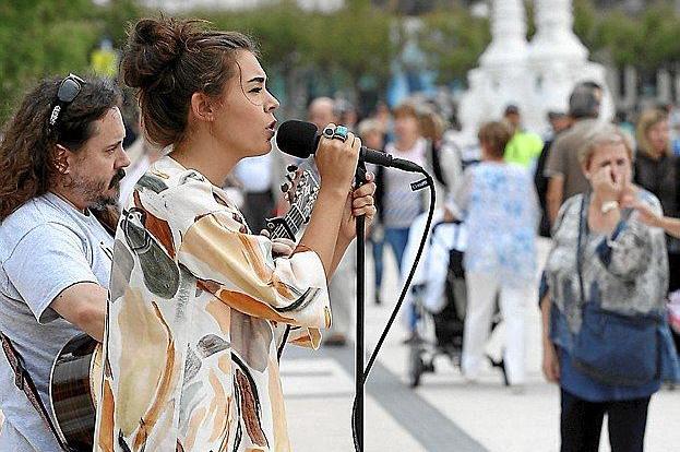 Una cantante y un guitarrista actúan en el paseo de La Concha.