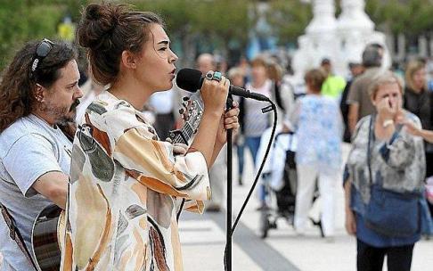 Una cantante y un guitarrista actúan en el paseo de La Concha.
