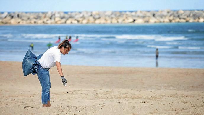 Una voluntaria participa en una limpieza de la playa de la Zurriola.