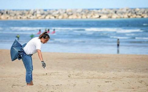 Una voluntaria participa en una limpieza de la playa de la Zurriola.