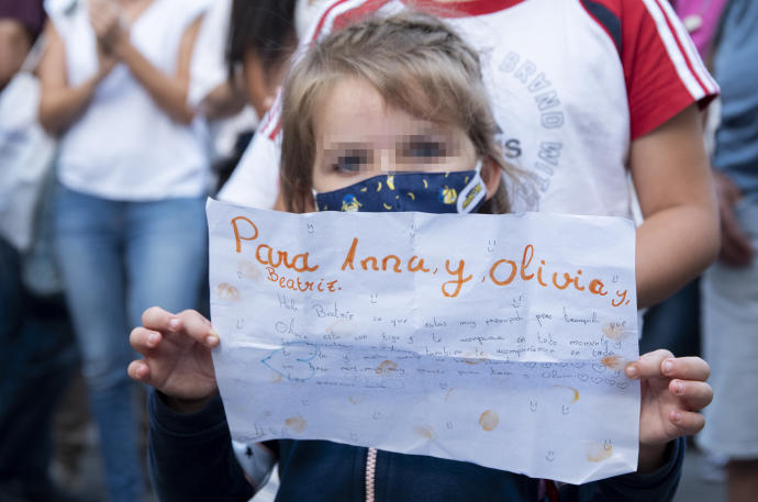 Una niña sostiene un papel con una carta a Olivia y Anna