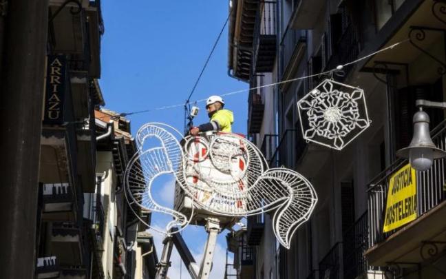 Un operario municipal coloca adornos navideños en la calle Pozo Blanco Un operario municipal coloca adornos navideños en la calle Pozo Blanco