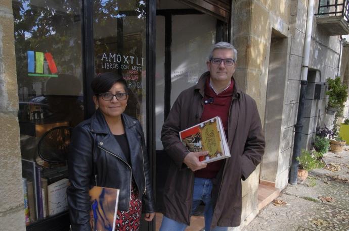 Yoania Torres y Javier Garísoain, posan en la entrada de la librería Amoxtli, en el número 10 de la plaza del ferial de Urroz-Villa.