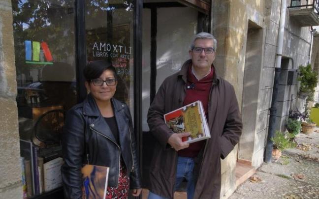 Yoania Torres y Javier Garísoain, posan en la entrada de la librería Amoxtli, en el número 10 de la plaza del ferial de Urroz-Villa.