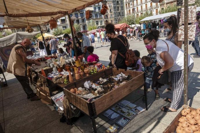 Visitantes del mercadillo medieval disfrutan las figuras de uno de los puestos de la Plaza del Castillo.