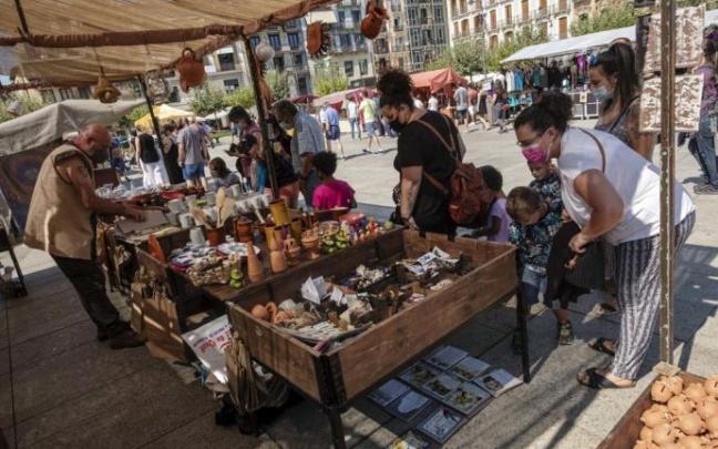 Visitantes del mercadillo medieval disfrutan las figuras de uno de los puestos de la Plaza del Castillo. Visitantes del mercadillo medieval disfrutan las figuras de uno de los puestos de la Plaza del Castillo.