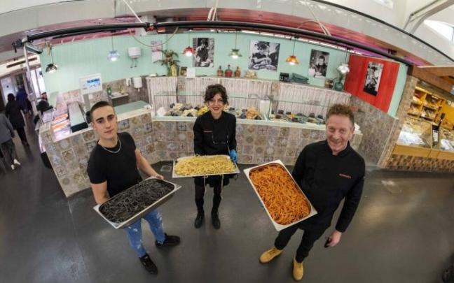 José Javier Oyarzun (derecha) y dos empleados posan con tres bandejas repletas de tallarines en el puesto del Mercado del II Ensanche.